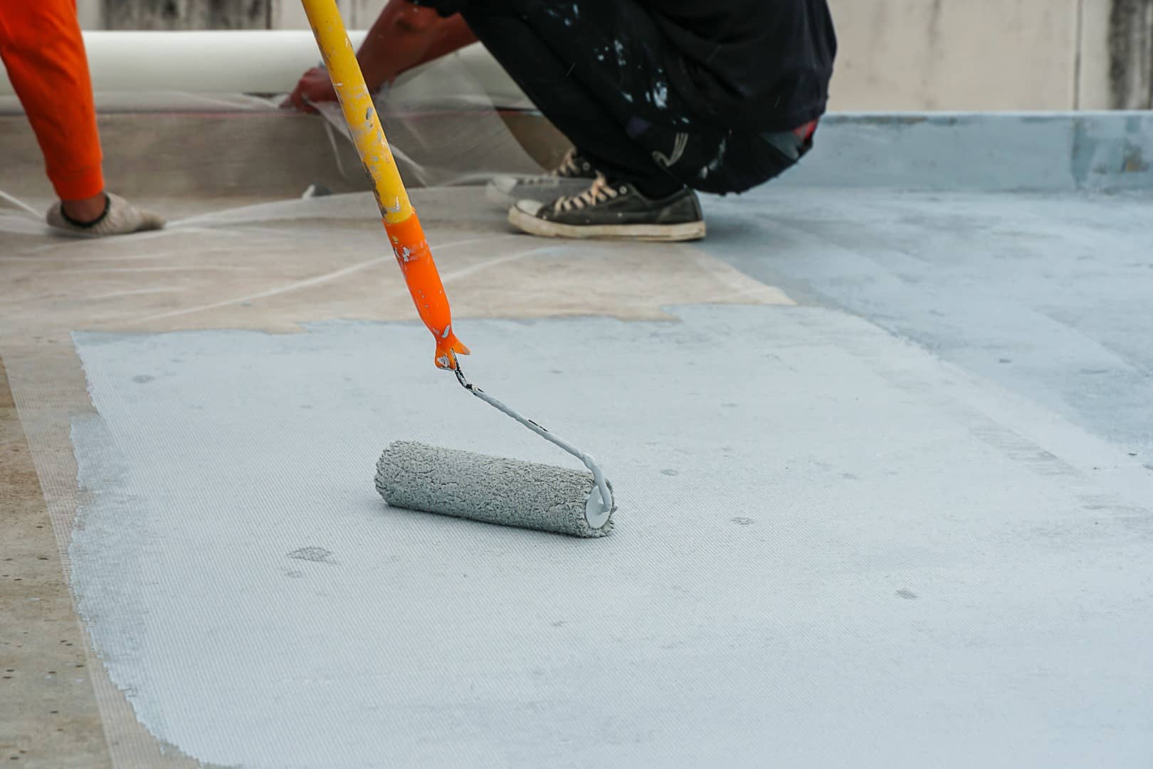 Hand painting concrete flooring.